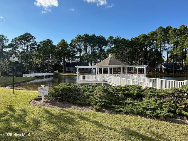 exterior space with a gazebo, a water view, a lawn, and fence