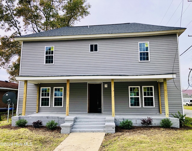 view of front of house with covered porch and a front yard