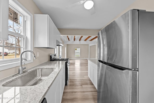 kitchen featuring stainless steel appliances, a wealth of natural light, white cabinets, and a sink