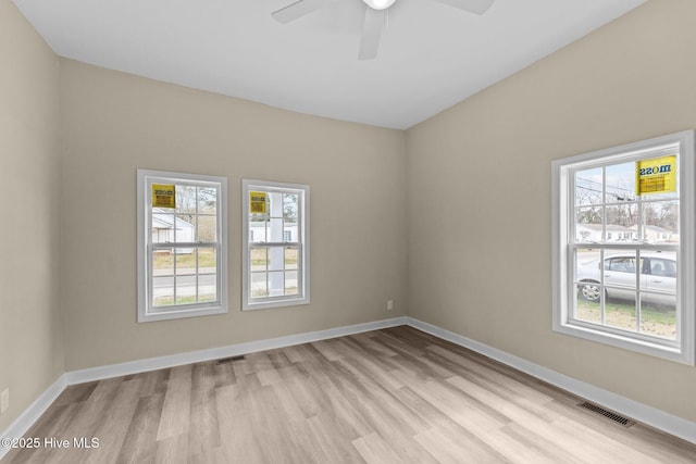 unfurnished room featuring a wealth of natural light, light wood-style flooring, and visible vents