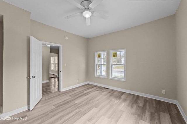 unfurnished room with light wood-type flooring, baseboards, and a ceiling fan