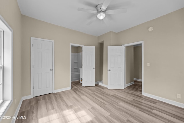 unfurnished bedroom featuring ceiling fan, light wood-type flooring, connected bathroom, and baseboards