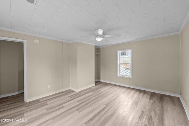 spare room with ornamental molding, wood finished floors, and baseboards