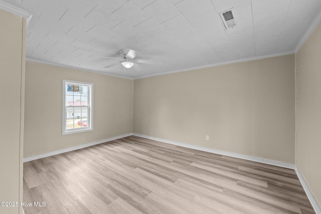 spare room featuring visible vents, ornamental molding, a ceiling fan, light wood-type flooring, and baseboards