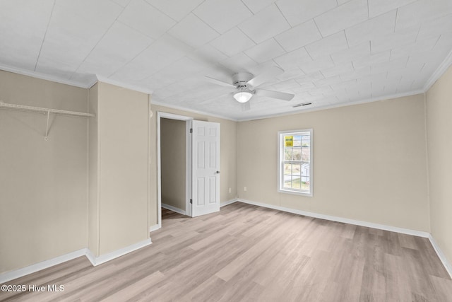 unfurnished bedroom featuring baseboards, light wood-type flooring, visible vents, and crown molding