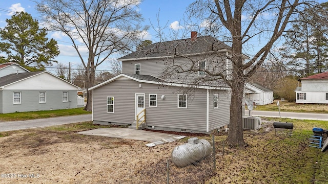 rear view of house with entry steps, central AC unit, and crawl space