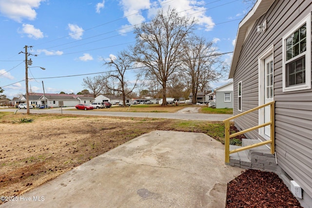 view of yard featuring entry steps and a residential view