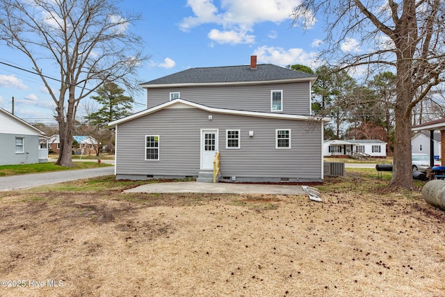 rear view of property featuring entry steps, a shingled roof, crawl space, and a chimney