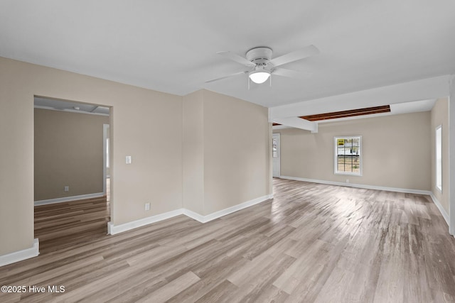 unfurnished room with ceiling fan, wood finished floors, and baseboards