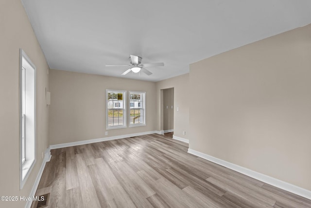 unfurnished room with light wood-type flooring, baseboards, and a ceiling fan