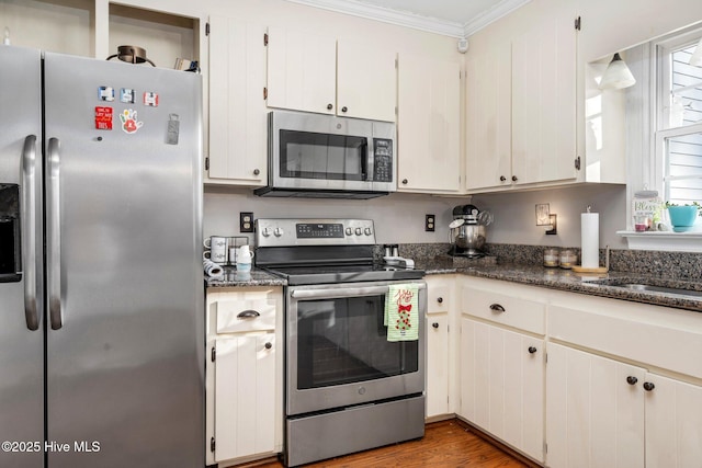 kitchen featuring white cabinetry, dark hardwood / wood-style flooring, stainless steel appliances, and ornamental molding