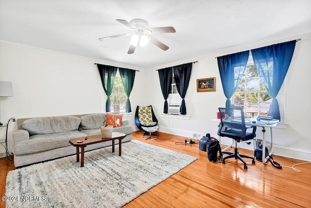 living room featuring hardwood / wood-style flooring, ceiling fan, and ornamental molding