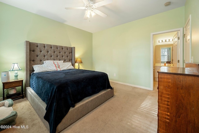 carpeted bedroom with ensuite bathroom and ceiling fan