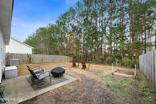 view of yard featuring central AC, an outdoor fire pit, and a patio area