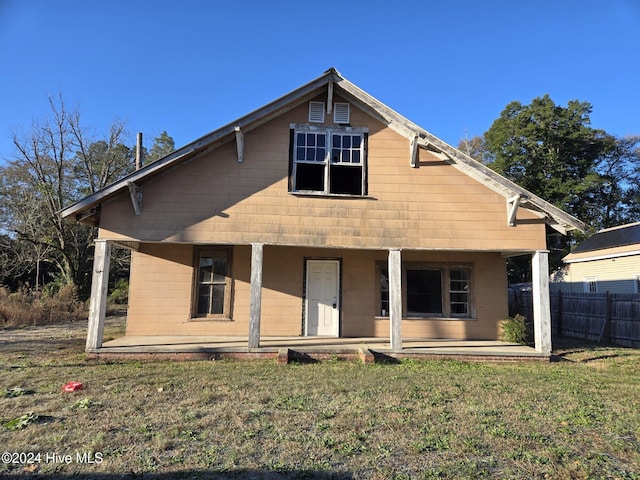 rear view of property featuring a lawn