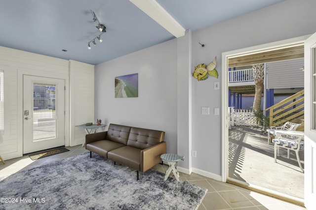 tiled living room featuring track lighting and baseboards