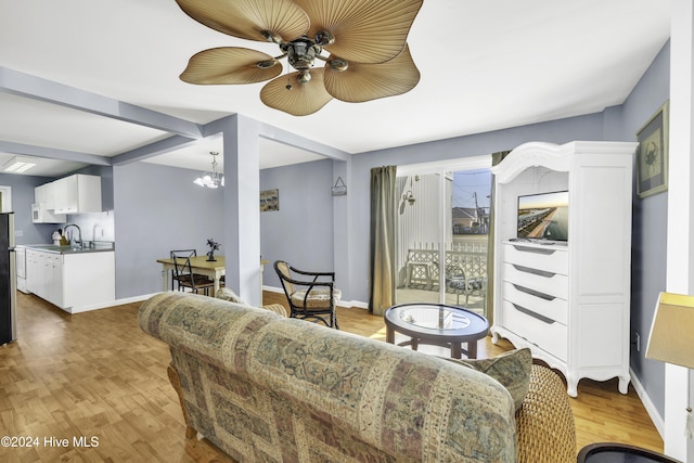 living room featuring baseboards, light wood finished floors, and a chandelier