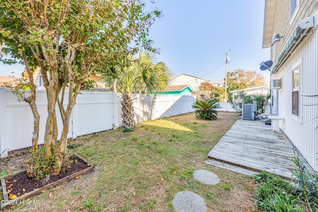 view of yard featuring cooling unit, a fenced backyard, and a wooden deck