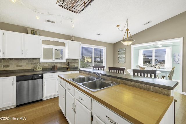 kitchen featuring visible vents, white cabinets, dishwasher, and a sink