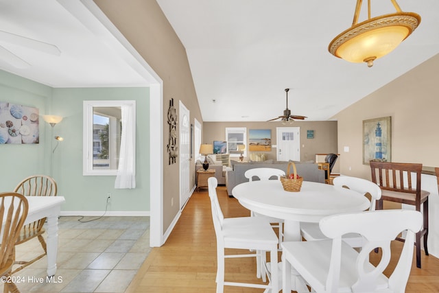 dining space featuring ceiling fan, light hardwood / wood-style flooring, and vaulted ceiling