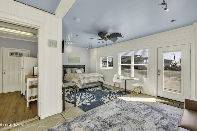 bedroom featuring tile patterned floors, freestanding refrigerator, and a ceiling fan