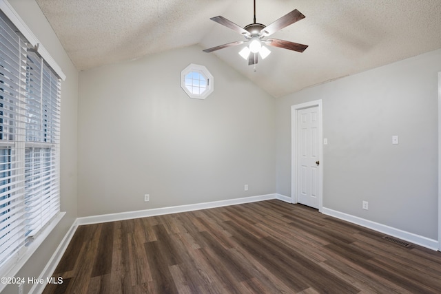 empty room featuring a textured ceiling, ceiling fan, dark hardwood / wood-style flooring, and lofted ceiling