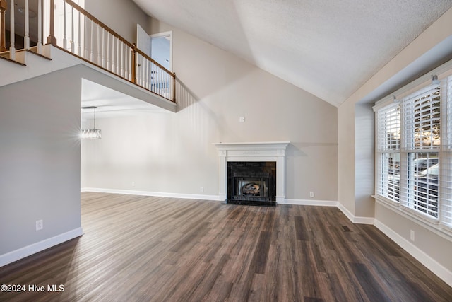 unfurnished living room with a textured ceiling, dark hardwood / wood-style floors, a fireplace, and high vaulted ceiling