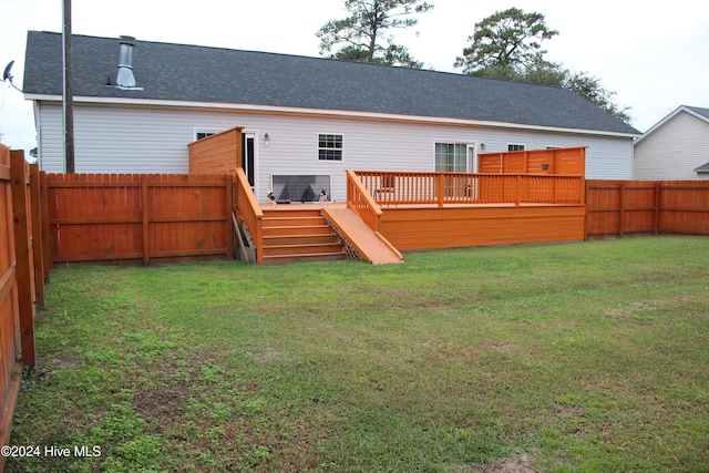 back of property featuring a yard and a wooden deck