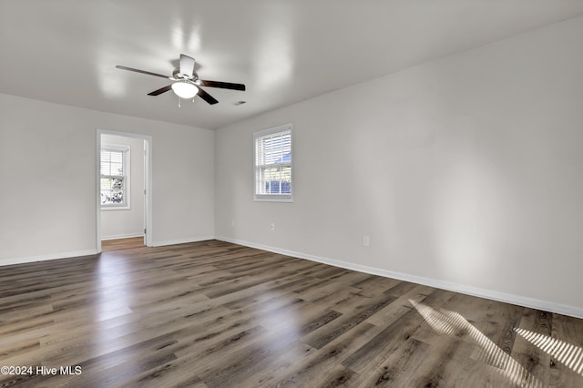 spare room with dark hardwood / wood-style floors, plenty of natural light, and ceiling fan