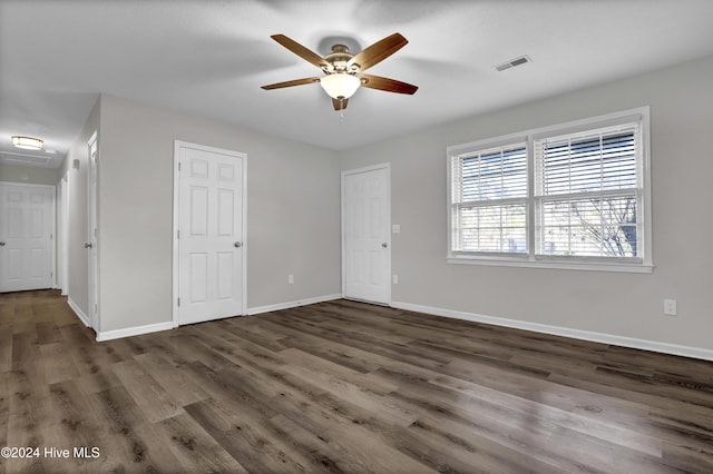 unfurnished bedroom featuring ceiling fan and dark hardwood / wood-style flooring