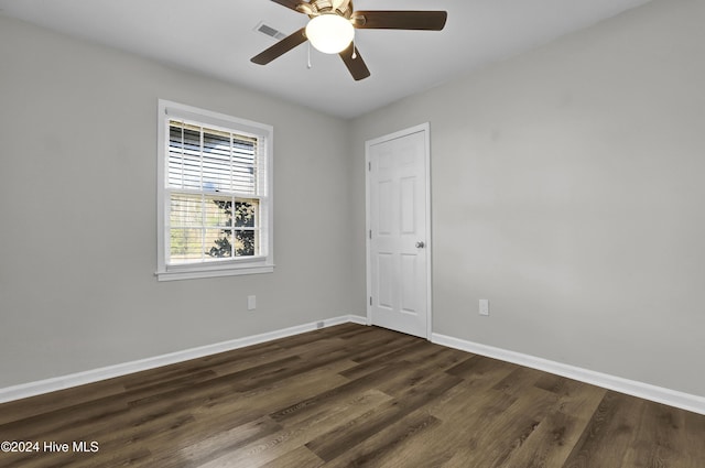 empty room with dark hardwood / wood-style flooring and ceiling fan