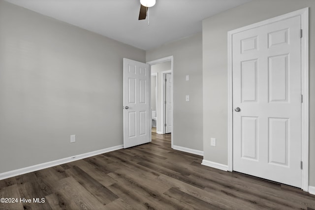 unfurnished bedroom with ceiling fan and dark wood-type flooring