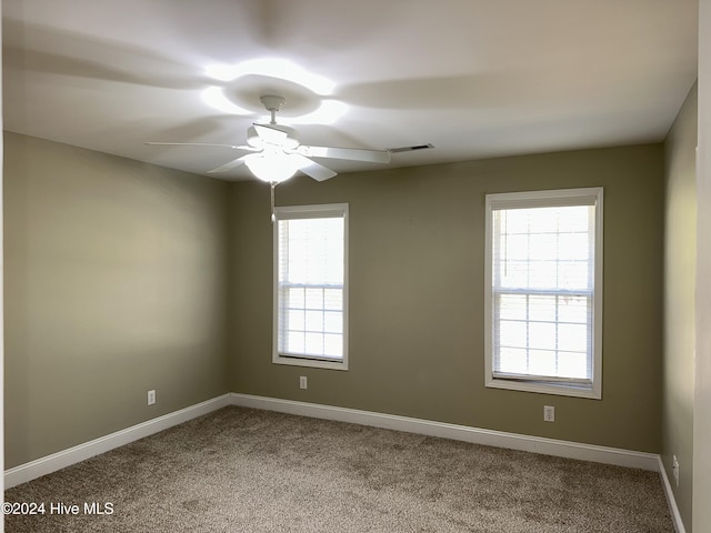 carpeted spare room featuring ceiling fan