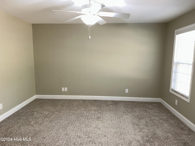 carpeted spare room featuring ceiling fan