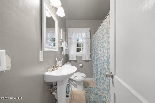 bathroom with toilet, tile patterned floors, and walk in shower