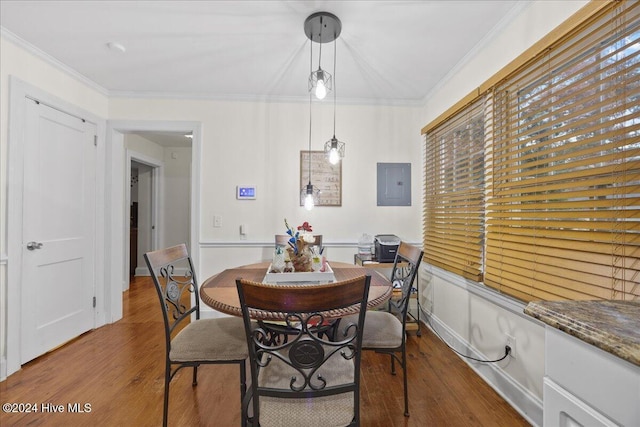 dining space with wood-type flooring, crown molding, and electric panel