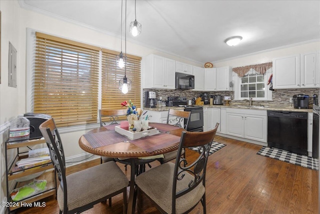 dining area featuring a healthy amount of sunlight, crown molding, sink, and electric panel