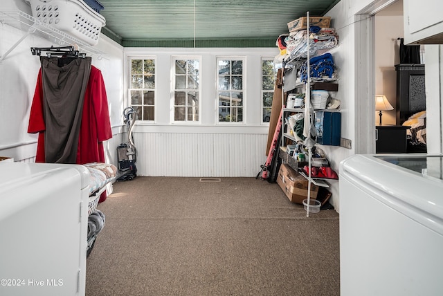 clothes washing area featuring carpet flooring, wood walls, and cabinets