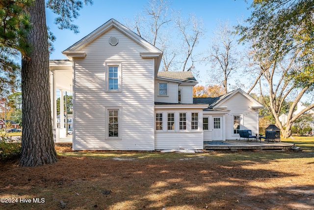 back of house featuring a lawn