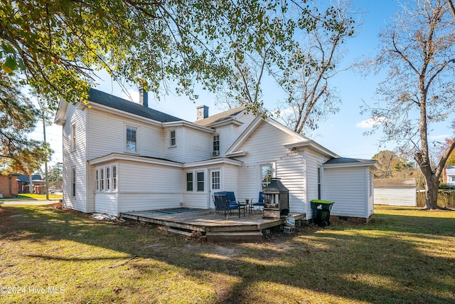 back of house featuring a lawn and a wooden deck