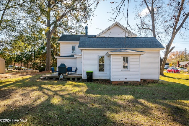 rear view of house with a yard and a wooden deck