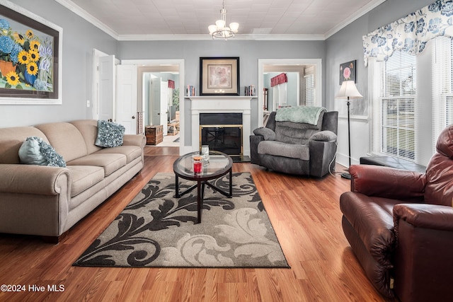 living room featuring hardwood / wood-style floors, crown molding, and an inviting chandelier