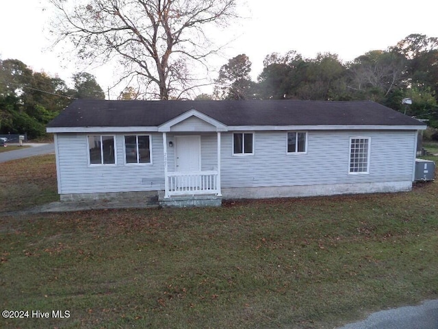 view of front of property with a front yard and central AC