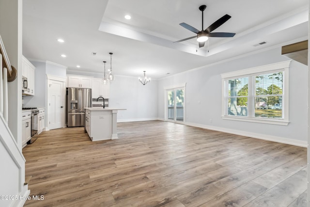 kitchen featuring white cabinets, a center island with sink, stainless steel appliances, and open floor plan