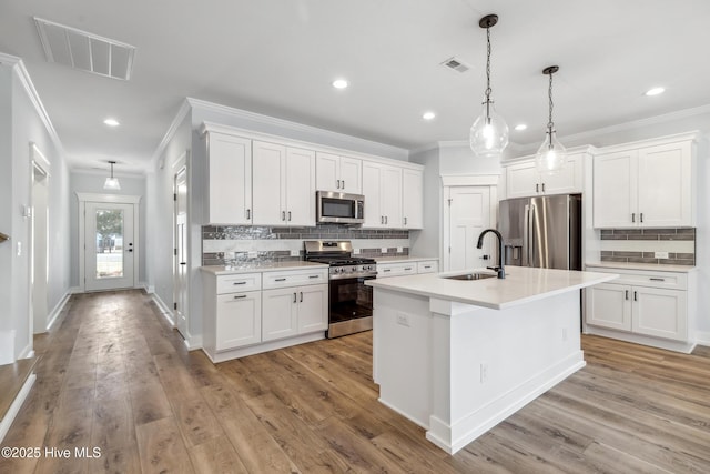 kitchen with stainless steel appliances, white cabinets, light countertops, and a sink