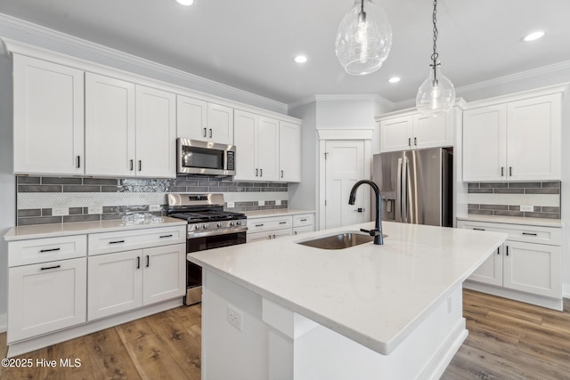 kitchen featuring an island with sink, appliances with stainless steel finishes, white cabinets, and a sink