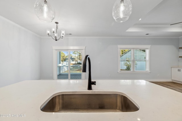 kitchen featuring light countertops, a sink, and decorative light fixtures