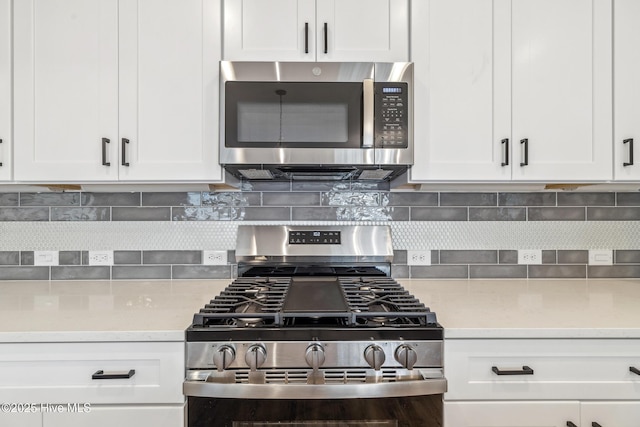 kitchen featuring tasteful backsplash, appliances with stainless steel finishes, and white cabinets