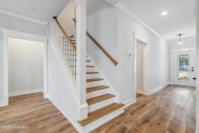 entryway featuring baseboards, stairway, crown molding, light wood-type flooring, and recessed lighting