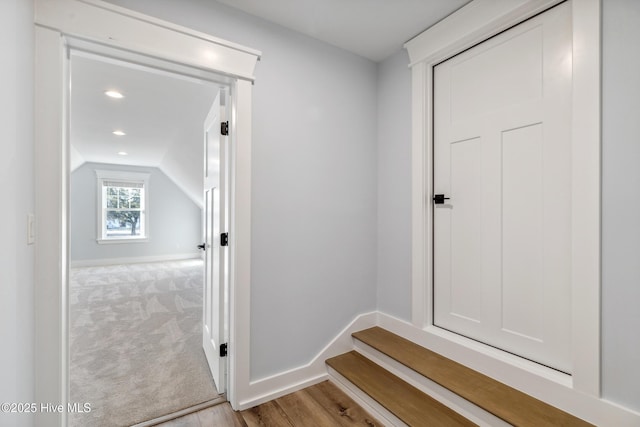 interior space with lofted ceiling, recessed lighting, light carpet, baseboards, and light wood-type flooring